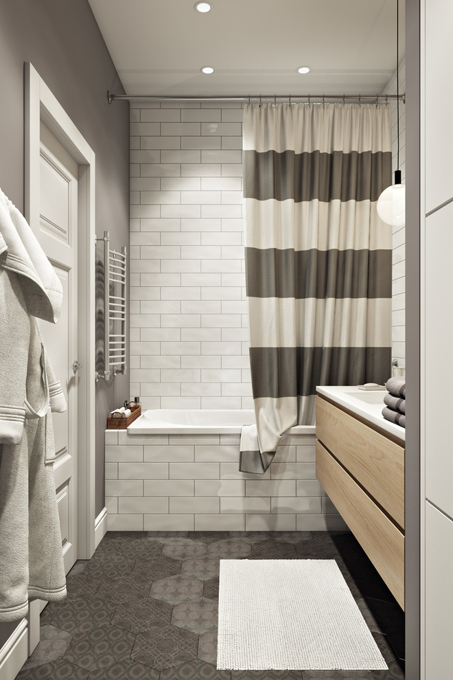 Mid-sized danish master white tile and ceramic tile porcelain tile and gray floor bathroom photo with flat-panel cabinets, light wood cabinets, an undermount tub, gray walls, a wall-mount sink, solid surface countertops and white countertops