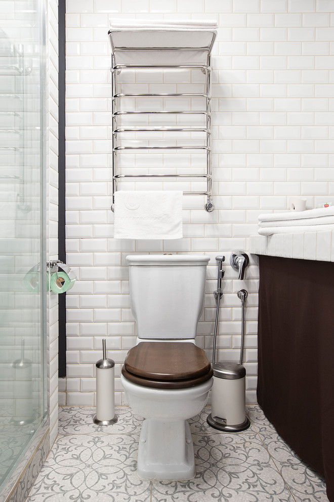 Skandinavisk inredning av ett mellanstort vit vitt badrum med dusch, med öppna hyllor, bruna skåp, våtrum, en toalettstol med separat cisternkåpa, vit kakel, tunnelbanekakel, vita väggar, klinkergolv i keramik, ett nedsänkt handfat, kaklad bänkskiva, beiget golv och dusch med skjutdörr