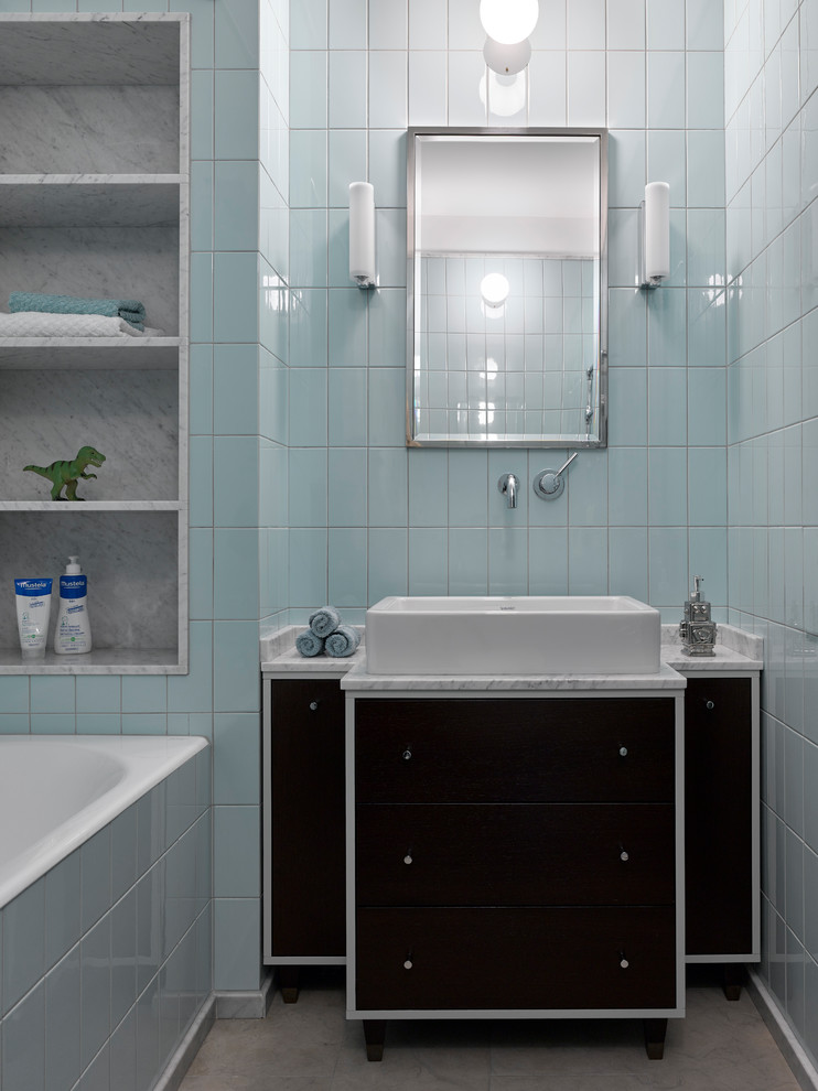 На фото: главная ванная комната в скандинавском стиле с плоскими фасадами, черными фасадами, ванной в нише, синей плиткой, настольной раковиной, бежевым полом и белой столешницей