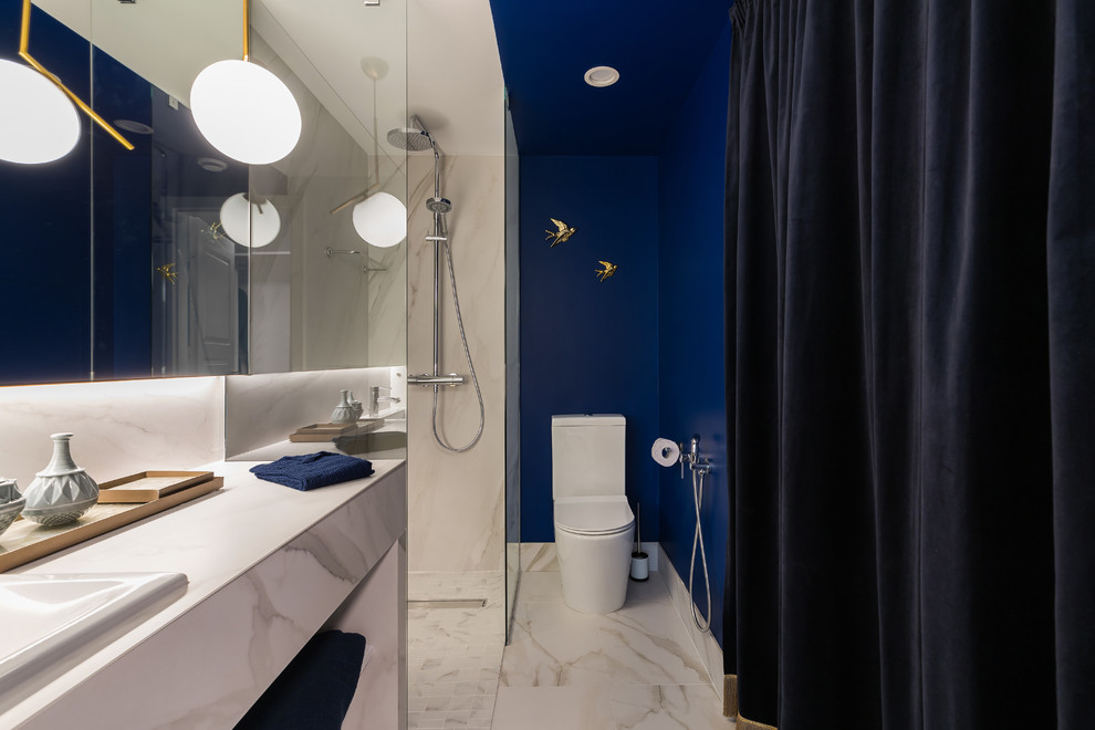 На фото: ванная комната в современном стиле с душем без бортиков, синими стенами, душевой кабиной, накладной раковиной, белым полом, унитазом-моноблоком, белой плиткой, мраморной плиткой, мраморным полом, мраморной столешницей, открытым душем и белой столешницей с