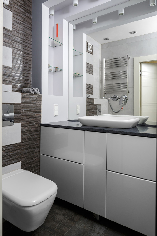 На фото: ванная комната в современном стиле с плоскими фасадами, белыми фасадами, раздельным унитазом, настольной раковиной и серым полом с