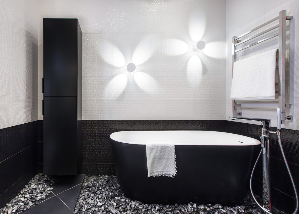Пример оригинального дизайна: главная ванная комната среднего размера в современном стиле с отдельно стоящей ванной, душем над ванной, керамической плиткой, полом из керамогранита, черным полом, белой плиткой и черной плиткой