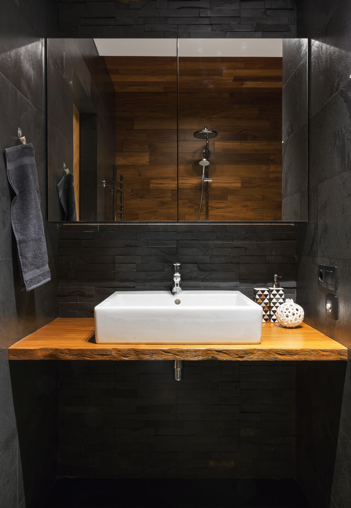 Foto de cuarto de baño urbano con lavabo sobreencimera, encimera de madera y encimeras marrones