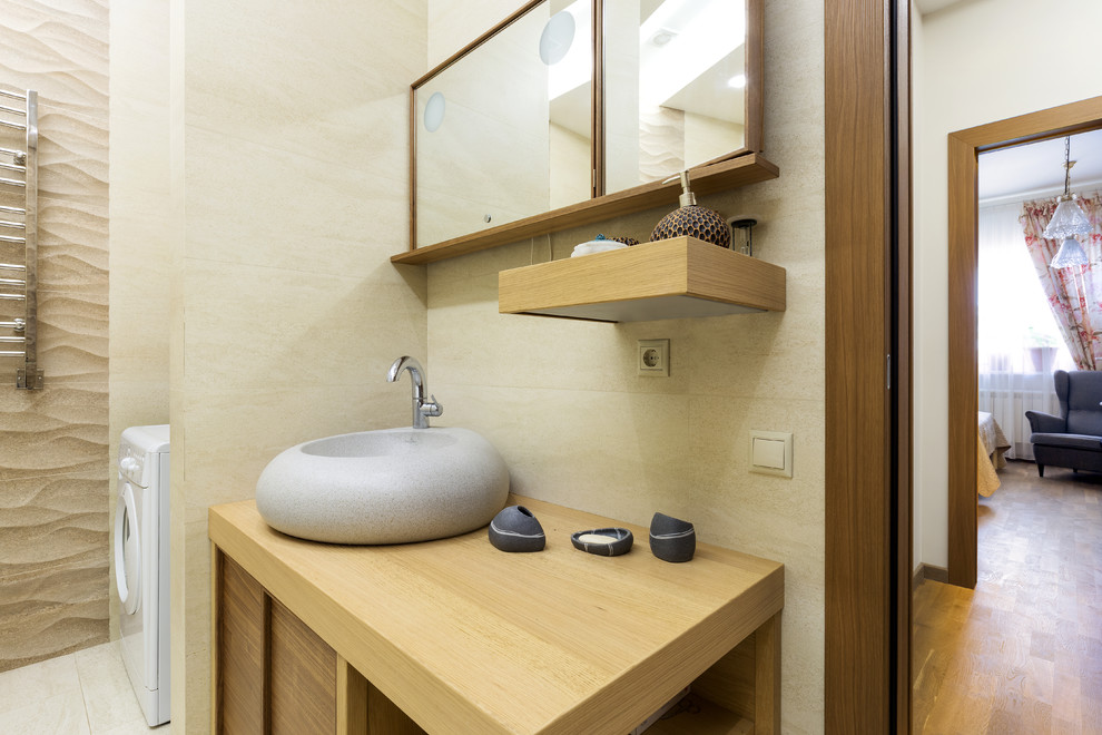 Источник вдохновения для домашнего уюта: ванная комната в современном стиле с бежевой плиткой, каменной плиткой, бежевыми стенами, столешницей из дерева и настольной раковиной
