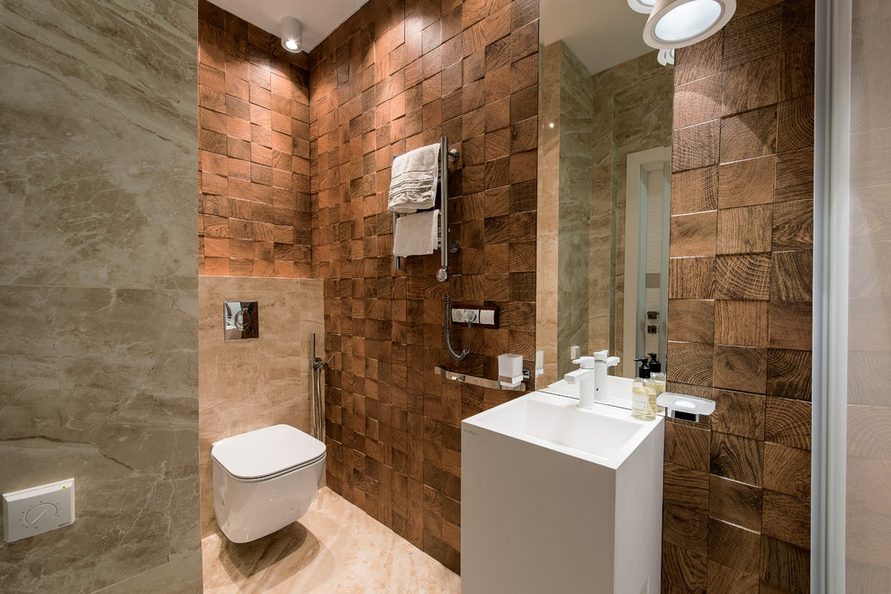 Idéer för mellanstora funkis badrum, med en vägghängd toalettstol, beige kakel, bruna väggar, ett piedestal handfat och beiget golv