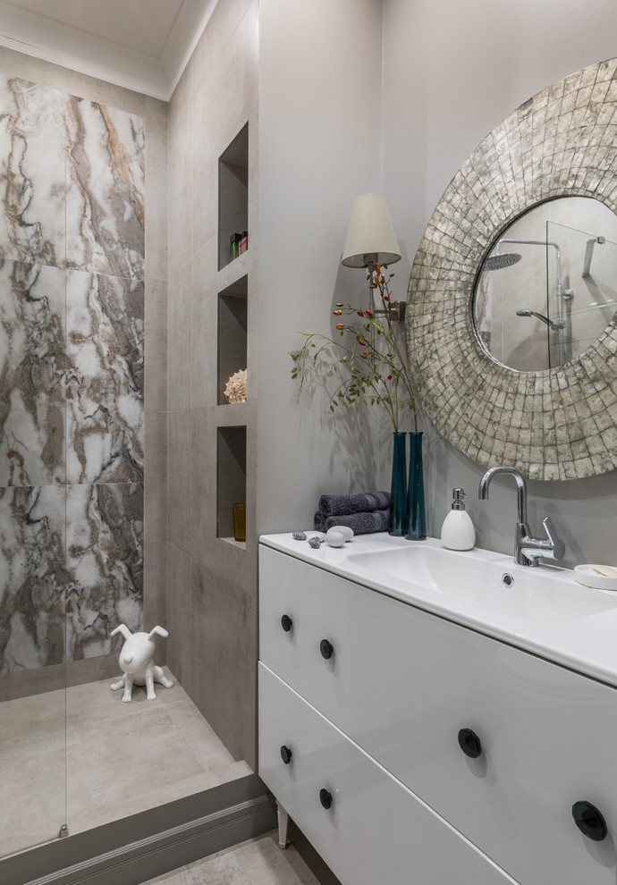 Modernes Duschbad mit flächenbündigen Schrankfronten, weißen Schränken, Duschnische, grauen Fliesen, integriertem Waschbecken und beigem Boden