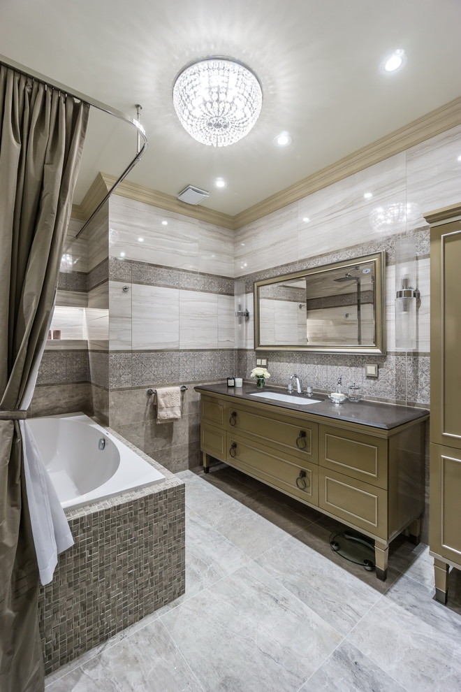 Idéer för ett mellanstort klassiskt en-suite badrum, med grå kakel, porslinskakel, klinkergolv i porslin, ett undermonterad handfat, bänkskiva i akrylsten, bruna skåp, en dusch/badkar-kombination, ett platsbyggt badkar och dusch med duschdraperi