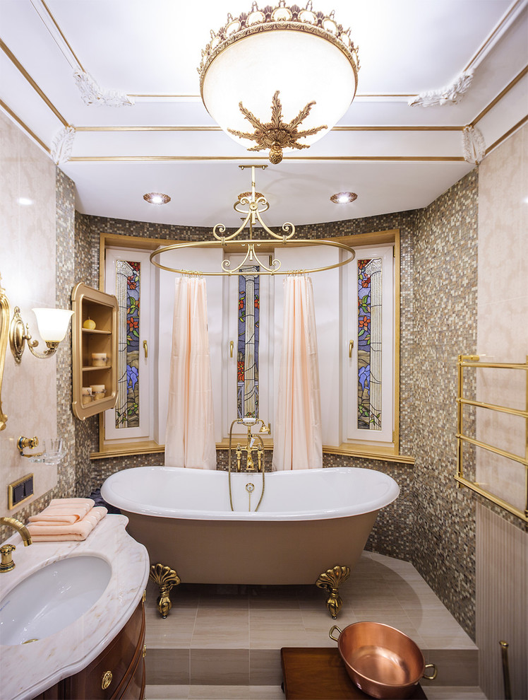 Идея дизайна: главная ванная комната в классическом стиле с ванной на ножках, бежевой плиткой, врезной раковиной и бежевой столешницей