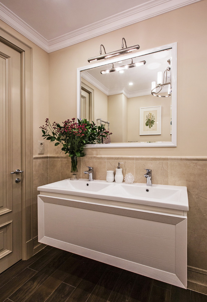 Idéer för att renovera ett mellanstort vintage en-suite badrum, med luckor med infälld panel, vita skåp, ett undermonterat badkar, en dusch i en alkov, en vägghängd toalettstol, beige kakel, keramikplattor, beige väggar, klinkergolv i porslin, ett avlångt handfat och brunt golv