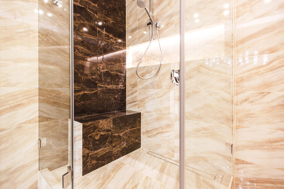 Inspiration for a medium sized contemporary ensuite bathroom in Moscow with flat-panel cabinets, beige cabinets, a corner bath, a walk-in shower, a wall mounted toilet, brown tiles, porcelain tiles, brown walls, porcelain flooring, a built-in sink, solid surface worktops, brown floors, a hinged door and brown worktops.