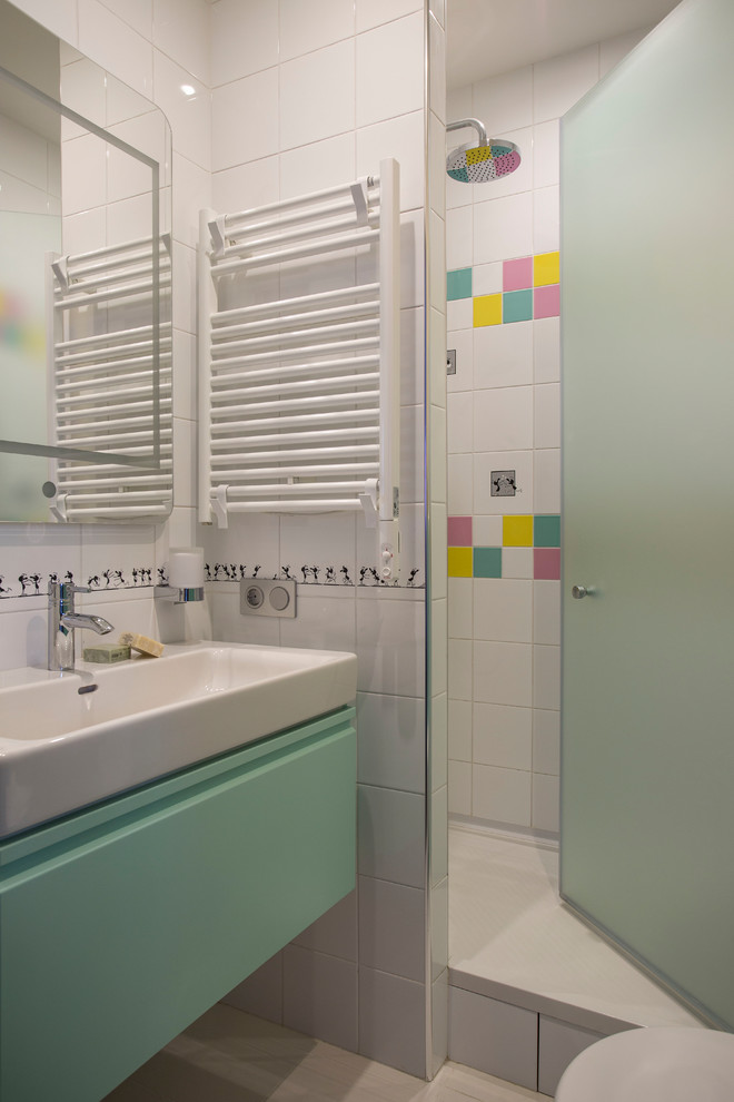 Immagine di una stanza da bagno per bambini design con ante lisce, ante turchesi, doccia alcova, piastrelle bianche, piastrelle multicolore, lavabo da incasso, porta doccia a battente e WC a due pezzi