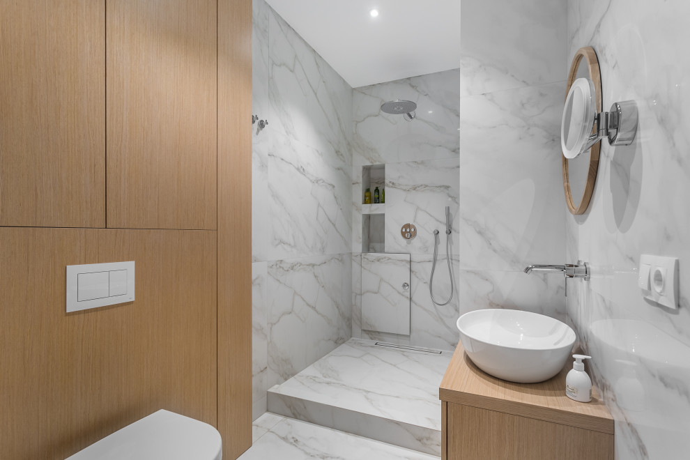 Photo of a medium sized contemporary shower room bathroom in Moscow with flat-panel cabinets, an alcove shower, a wall mounted toilet, a vessel sink, an open shower, a single sink, light wood cabinets, grey tiles, porcelain tiles, wooden worktops, grey floors, beige worktops and a wall niche.