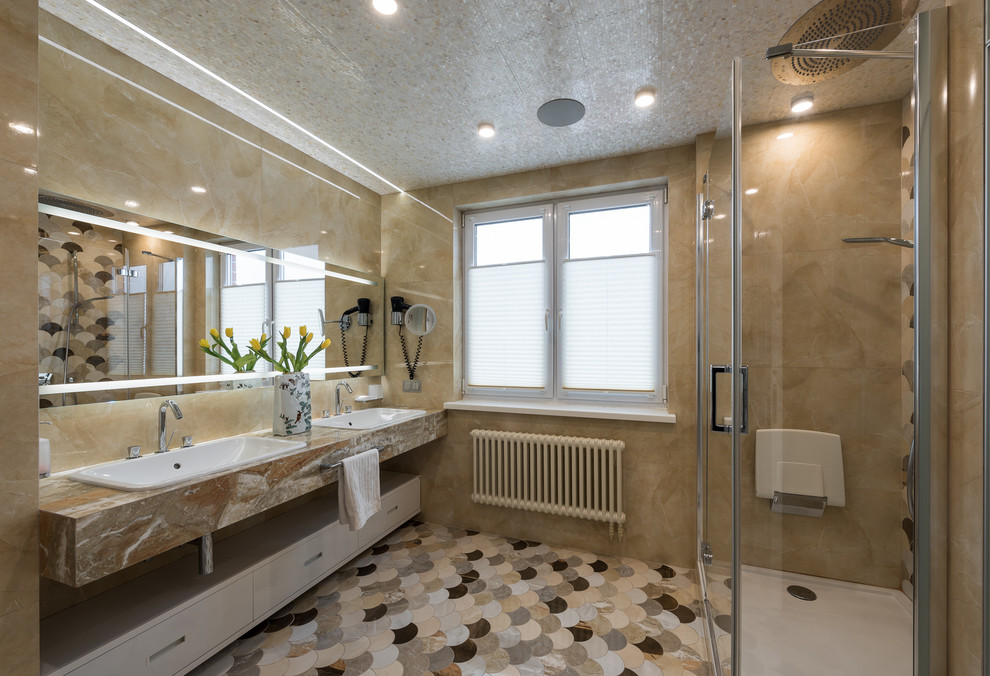 На фото: большая ванная комната в современном стиле с плоскими фасадами, коричневыми фасадами, бежевой плиткой, керамогранитной плиткой, бежевыми стенами, полом из керамогранита, столешницей из искусственного камня, угловым душем, душевой кабиной и накладной раковиной с