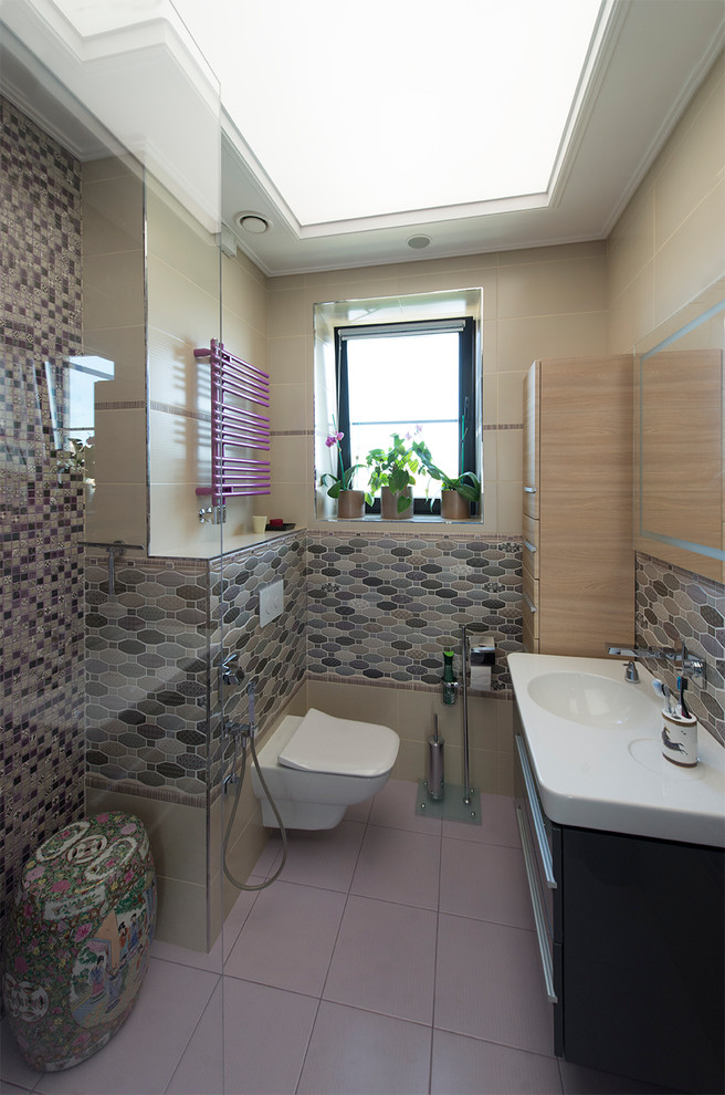 Bild på ett mellanstort funkis badrum för barn, med släta luckor, grå skåp, en vägghängd toalettstol, flerfärgad kakel, keramikplattor, klinkergolv i porslin och ett integrerad handfat