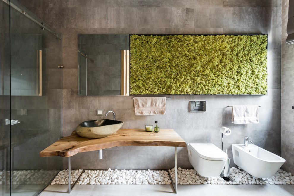 Immagine di una stanza da bagno con doccia contemporanea di medie dimensioni con nessun'anta, ante marroni, doccia a filo pavimento, WC a due pezzi, piastrelle in ceramica, pareti beige, pavimento in gres porcellanato, lavabo da incasso, top in legno, pavimento grigio, porta doccia a battente, top marrone e piastrelle grigie