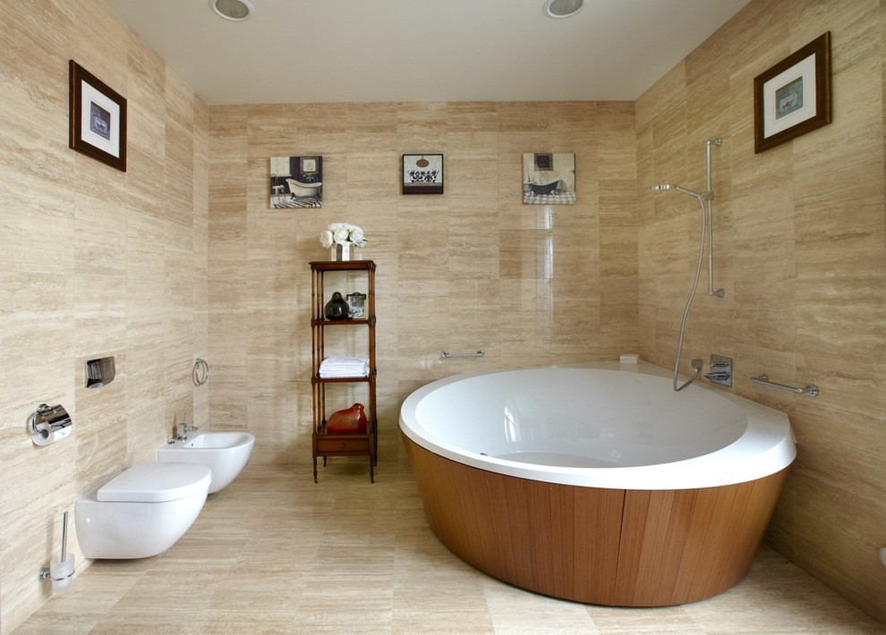 Inredning av ett modernt en-suite badrum, med ett fristående badkar, en dusch/badkar-kombination, en vägghängd toalettstol och beige kakel