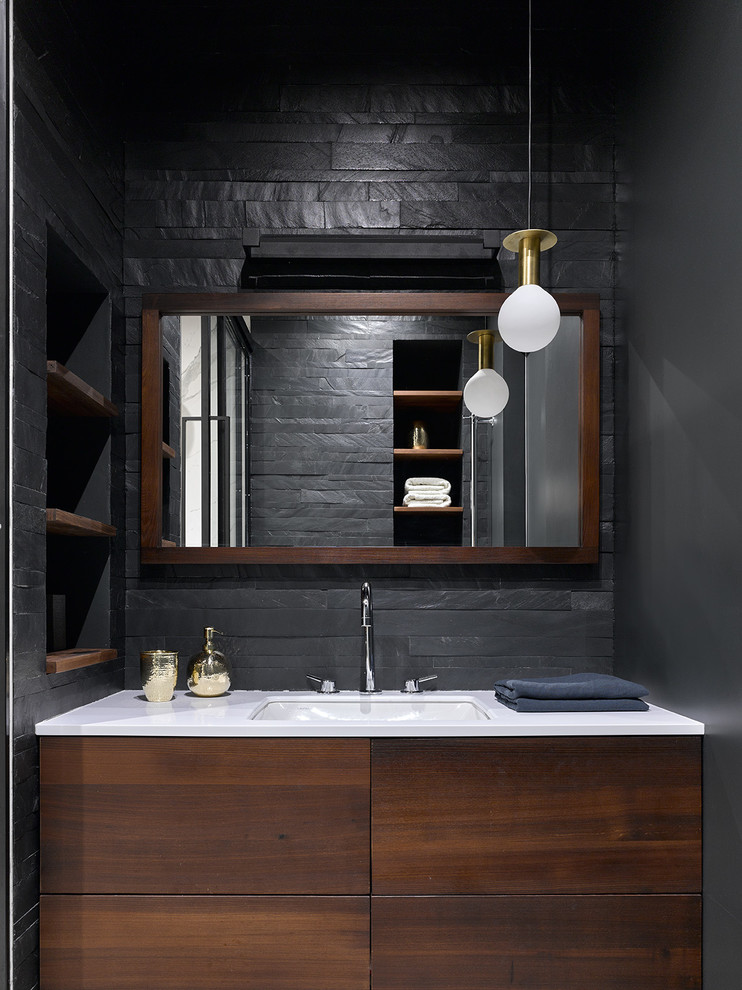 Идея дизайна: ванная комната в современном стиле с плоскими фасадами, темными деревянными фасадами, черной плиткой, врезной раковиной и белой столешницей