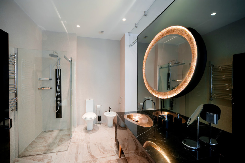 Modelo de cuarto de baño contemporáneo con lavabo integrado, puertas de armario negras, ducha a ras de suelo, bidé y espejo con luz