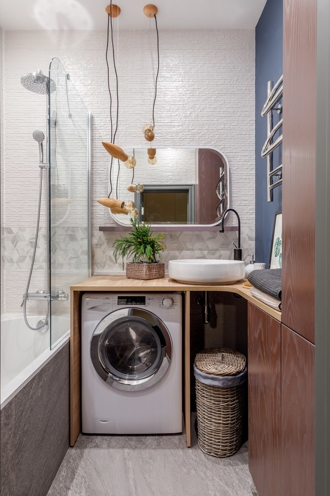 Inspiration för moderna brunt badrum, med släta luckor, skåp i mörkt trä, ett badkar i en alkov, en dusch/badkar-kombination, vit kakel, blå väggar, ett fristående handfat, träbänkskiva, grått golv och med dusch som är öppen