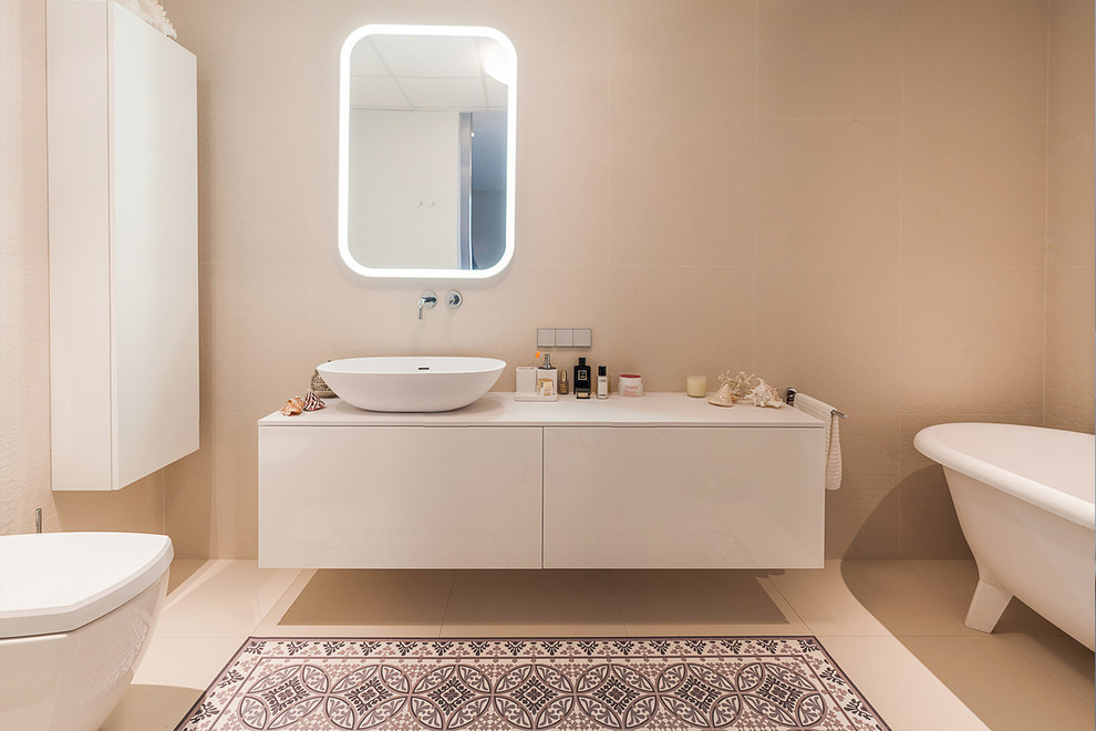 Пример оригинального дизайна: главная ванная комната в современном стиле с плоскими фасадами, белыми фасадами, ванной на ножках, бежевой плиткой, настольной раковиной, бежевым полом и белой столешницей