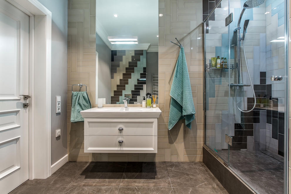 Aménagement d'une salle de bain contemporaine avec un placard avec porte à panneau encastré, des portes de placard blanches, un carrelage multicolore, un mur gris, un lavabo intégré, un sol marron et une cabine de douche à porte battante.