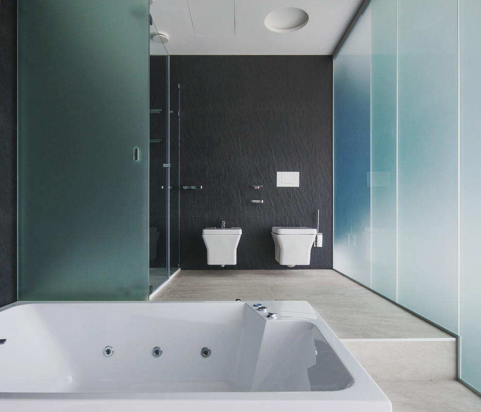 Imagen de cuarto de baño actual grande con sanitario de pared y paredes negras