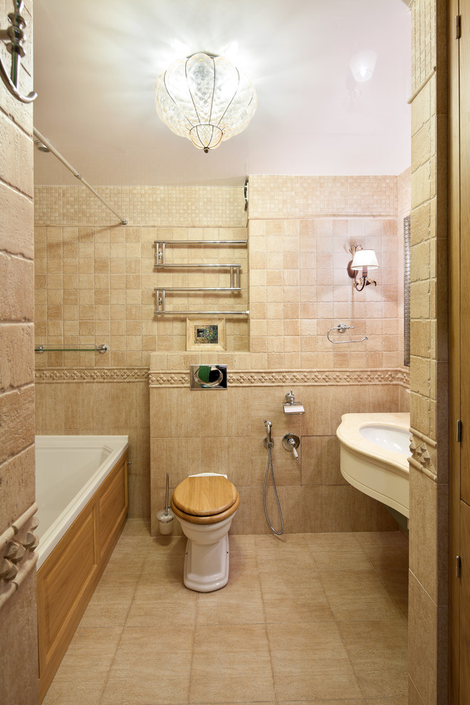 Esempio di una stanza da bagno mediterranea con vasca ad alcova, WC sospeso, lavabo sottopiano, pareti beige e pavimento in gres porcellanato