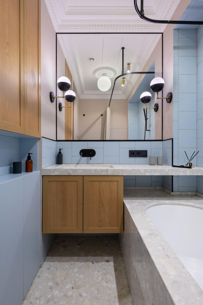 Cette image montre une salle de bain principale et longue et étroite minimaliste en bois brun de taille moyenne avec un placard avec porte à panneau encastré, une baignoire encastrée, un carrelage bleu, un sol en terrazzo, un lavabo encastré, un plan de toilette en terrazzo, un sol gris et un plan de toilette gris.