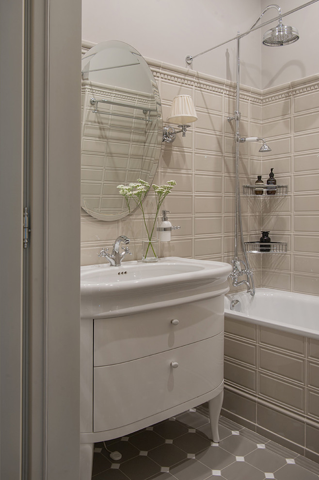 Foto på ett mellanstort vintage badrum med dusch, med beige skåp, ett badkar i en alkov, en dusch/badkar-kombination, beige kakel, porslinskakel, grå väggar, klinkergolv i porslin, ett undermonterad handfat, grått golv och släta luckor