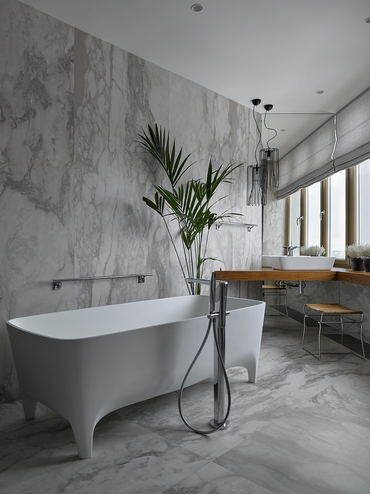 Inspiration for a medium sized contemporary ensuite bathroom in Moscow with a claw-foot bath, grey tiles, porcelain tiles, porcelain flooring, wooden worktops, a vessel sink, grey floors and brown worktops.