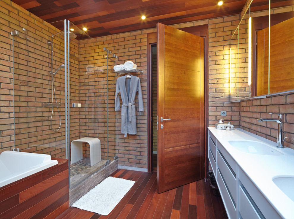 Inspiration pour une salle de bain design avec un placard à porte plane, des portes de placard blanches, parquet foncé, un lavabo encastré et un sol marron.