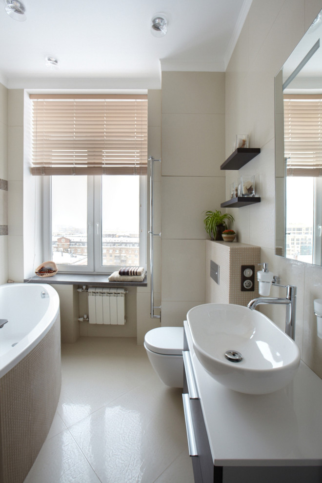 Источник вдохновения для домашнего уюта: ванная комната среднего размера в современном стиле с угловой ванной, инсталляцией, серой плиткой, керамогранитной плиткой, серыми стенами, полом из керамогранита и настольной раковиной