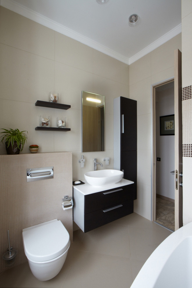 Inspiration pour une salle de bain design de taille moyenne avec une baignoire d'angle, WC suspendus, un carrelage gris, des carreaux de porcelaine, un mur gris, un sol en carrelage de porcelaine, une vasque et un plan de toilette en stratifié.