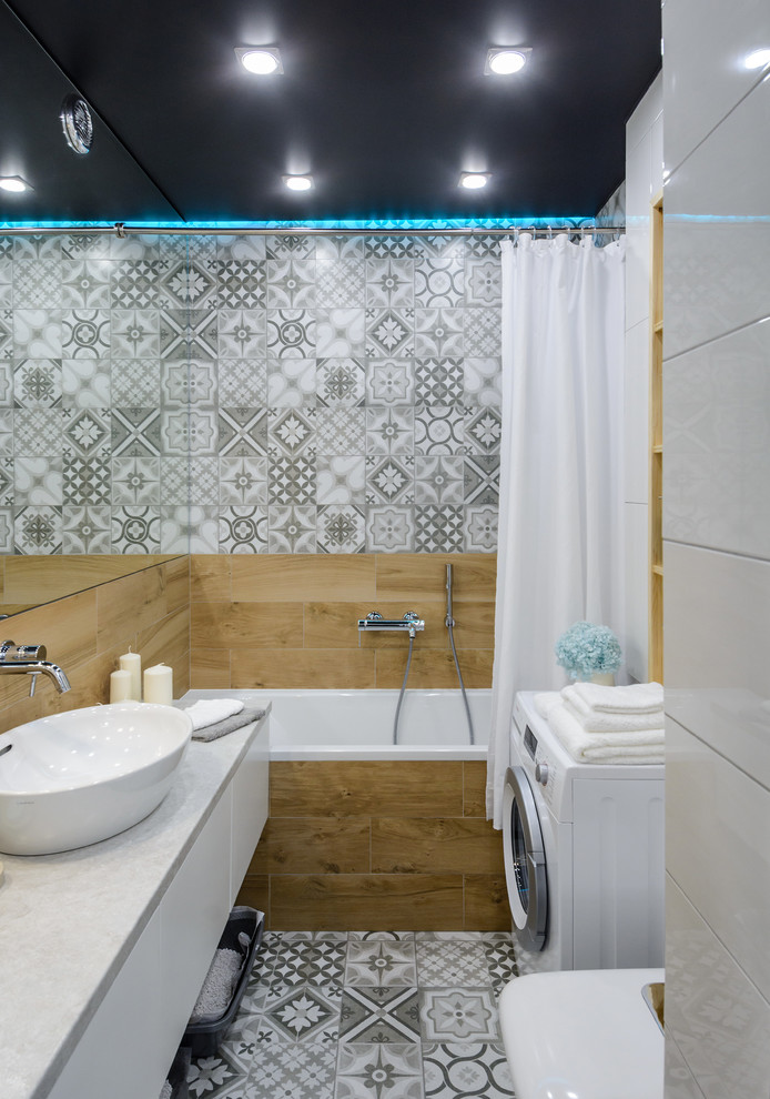 Modern inredning av ett litet grå grått en-suite badrum, med släta luckor, vita skåp, en dusch/badkar-kombination, porslinskakel, klinkergolv i porslin, laminatbänkskiva, grått golv, dusch med duschdraperi, ett badkar i en alkov, grå kakel och ett fristående handfat