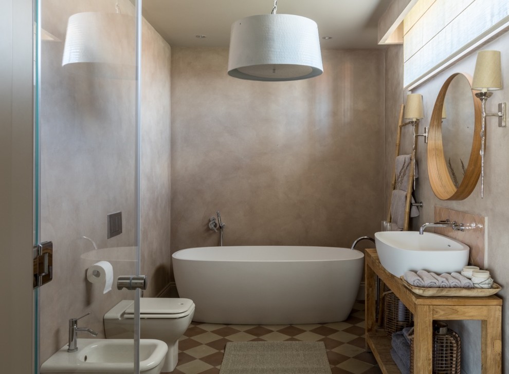 Idéer för ett medelhavsstil en-suite badrum, med öppna hyllor, ett fristående badkar, en bidé, beige väggar och ett fristående handfat
