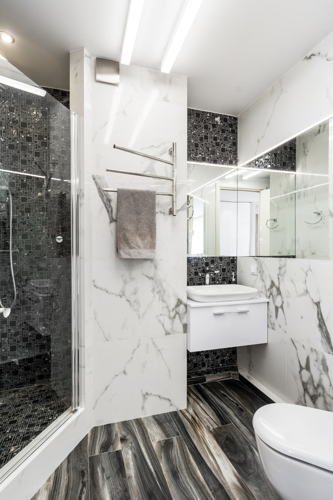 На фото: ванная комната в современном стиле с плоскими фасадами, белыми фасадами, угловым душем, черно-белой плиткой, черной плиткой, душевой кабиной, настольной раковиной, черным полом и душем с распашными дверями