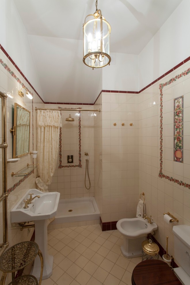 Immagine di una stanza da bagno tradizionale con doccia alcova, bidè, piastrelle beige e lavabo a colonna