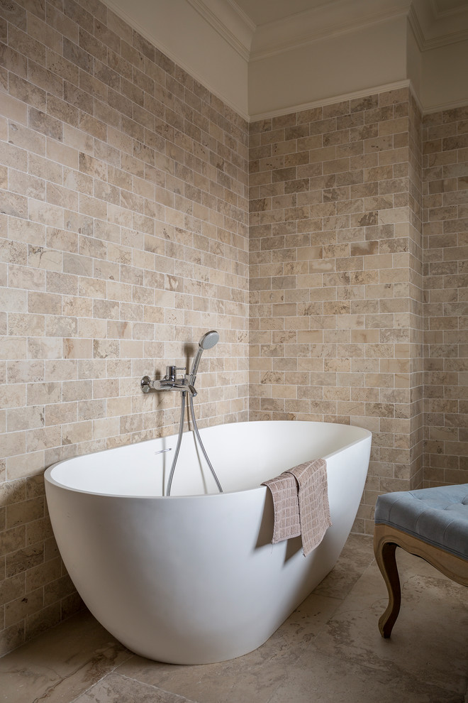 Пример оригинального дизайна: ванная комната среднего размера в стиле неоклассика (современная классика) с отдельно стоящей ванной, бежевой плиткой, мраморной плиткой и бежевым полом