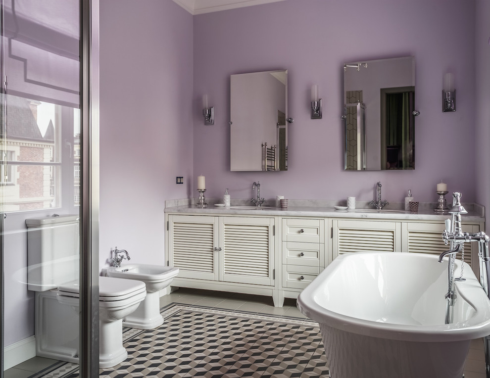 Свежая идея для дизайна: большая главная ванная комната в стиле неоклассика (современная классика) с белыми фасадами, раздельным унитазом, разноцветным полом, фасадами с филенкой типа жалюзи, отдельно стоящей ванной, угловым душем, фиолетовыми стенами и врезной раковиной - отличное фото интерьера
