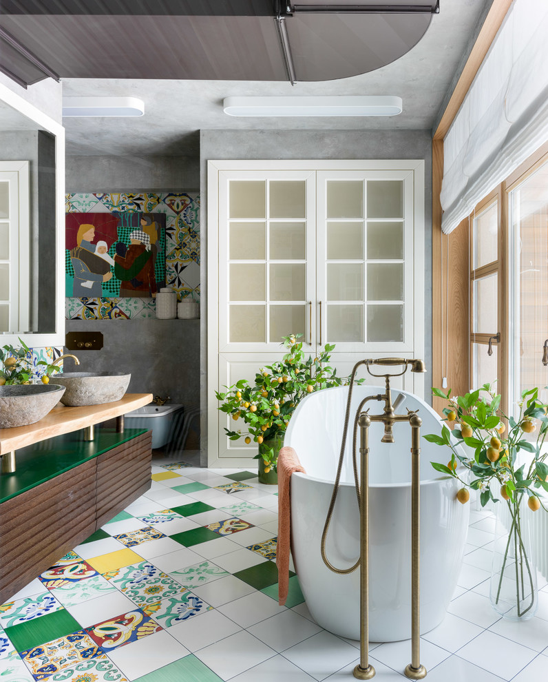 Inspiration pour une salle de bain principale bohème en bois brun avec une baignoire indépendante, un mur gris, une vasque, un plan de toilette en bois, un sol multicolore, un plan de toilette beige et un placard à porte plane.
