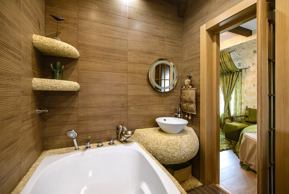 Foto på ett litet medelhavsstil beige badrum för barn, med ett undermonterat badkar, en vägghängd toalettstol, brun kakel, keramikplattor, bruna väggar, mosaikgolv, ett nedsänkt handfat, kaklad bänkskiva och beiget golv