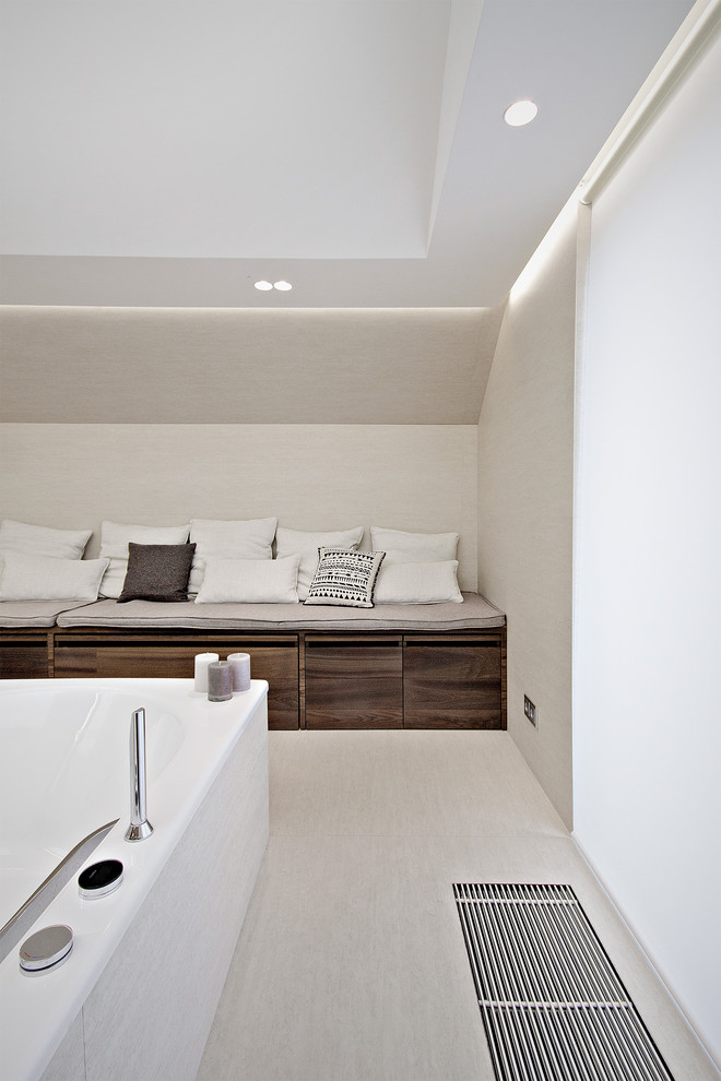 Foto på ett funkis badrum, med ett fristående badkar och grå väggar