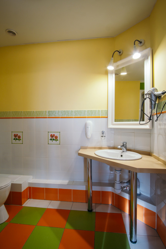 Стильный дизайн: ванная комната в стиле ретро с светлыми деревянными фасадами, угловым душем, белой плиткой, керамической плиткой, желтыми стенами, полом из керамической плитки, душевой кабиной, накладной раковиной, белым полом, душем с раздвижными дверями и тумбой под одну раковину - последний тренд