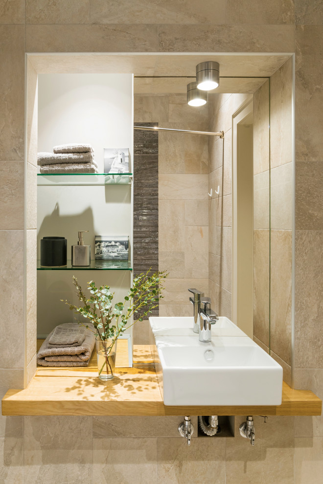 Immagine di una stanza da bagno design con piastrelle beige e lavabo a bacinella