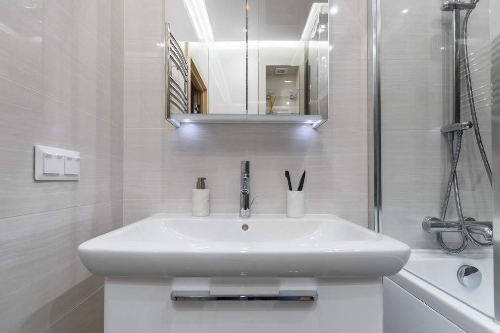 Ejemplo de cuarto de baño principal actual con armarios con paneles lisos, puertas de armario blancas, bañera empotrada, combinación de ducha y bañera, baldosas y/o azulejos marrones y lavabo integrado