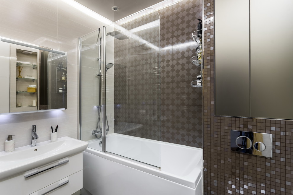 Ispirazione per una stanza da bagno padronale design con ante lisce, ante bianche, vasca ad alcova, vasca/doccia, piastrelle marroni e lavabo integrato