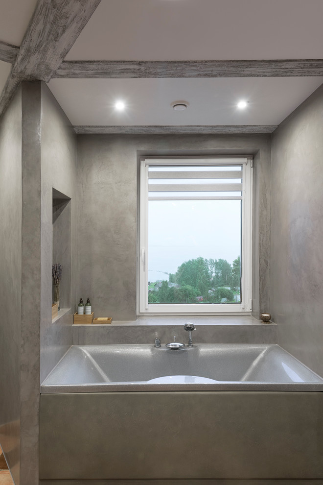 На фото: ванная комната в современном стиле с ванной в нише и серыми стенами