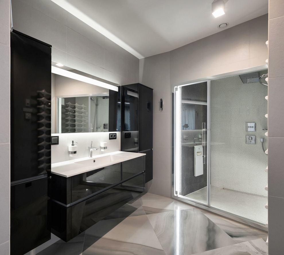 Imagen de cuarto de baño actual de tamaño medio con armarios con paneles lisos, puertas de armario negras, encimera de acrílico, ducha con puerta corredera, ducha empotrada y lavabo integrado