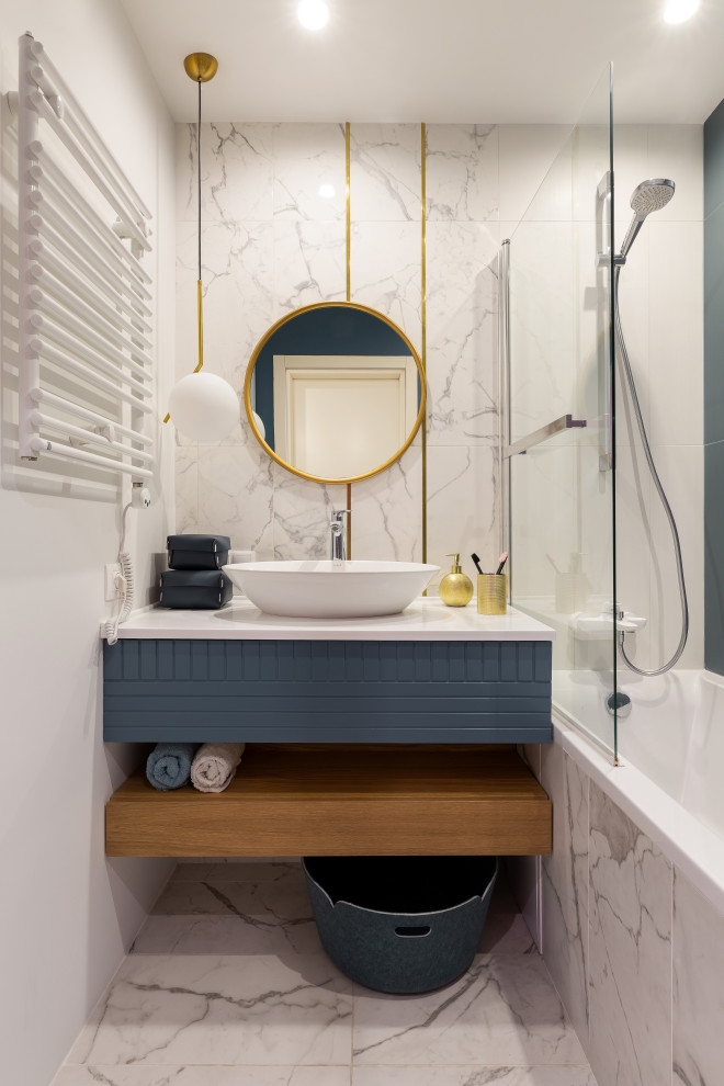 На фото: главная ванная комната в современном стиле с плоскими фасадами, серыми фасадами, ванной в нише, душем над ванной, белой плиткой, белыми стенами, настольной раковиной, белым полом и белой столешницей