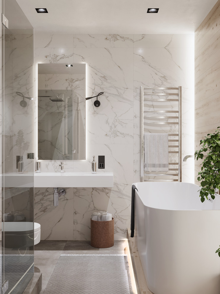 Inspiration for a small contemporary shower room bathroom in Valencia with a freestanding bath, a wall mounted toilet, beige tiles, porcelain tiles, multi-coloured walls, porcelain flooring, a wall-mounted sink, solid surface worktops, grey floors, a hinged door and white worktops.
